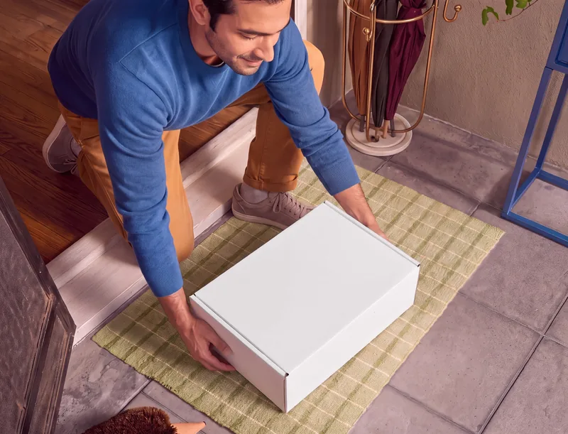 A white HeMed delivery box lifted from a doormat